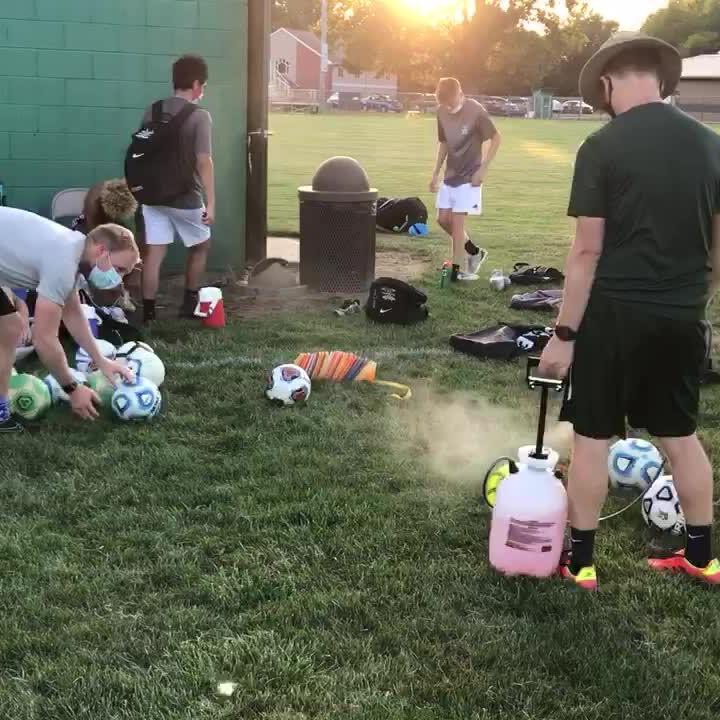 Northridge boys soccer coaches sanitize the soccer balls after practice